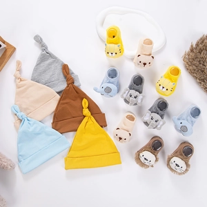Flat lay of knit baby beanies and anti-slip socks with cute 3D animal characters