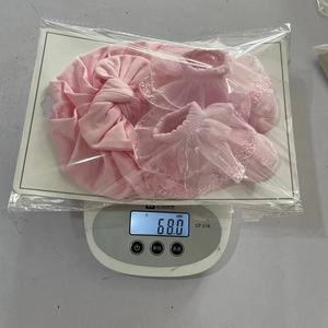 Pink cotton baby accessory set with lace socks and big bow headband in retail packaging