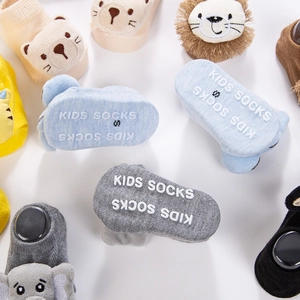 Detailed view of non-slip silicone grips on colorful cotton baby socks with animal motifs