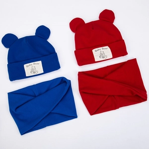 Detailed view of red and blue knitted baby hat and scarf sets with bear ears