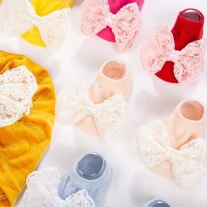 Vue détaillée de chaussettes en coton tricoté pour bébé avec grands nœuds en dentelle