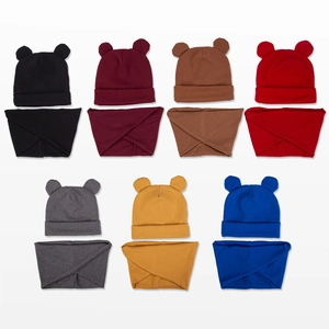 Detailed flat lay of knit baby bear hats and matching scarves set in seven diverse colors