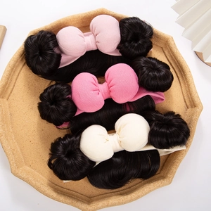 Close-up of cotton baby headbands with large bows and cute synthetic hair buns on a tray