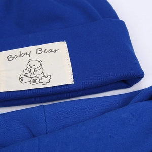 Detail of baby bear patch and woven texture on royal blue knitted baby hat set