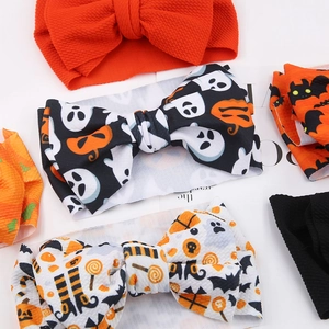 Detail of Halloween baby headbands featuring ghost and pumpkin prints on textured fabric