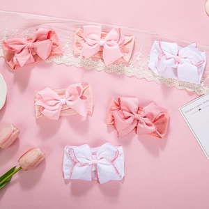 Detail view of 6-piece baby bow headbands set with soft nylon material and flat lay styling