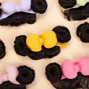 Close-up of baby headbands with double bun wigs and colorful bows for photography props