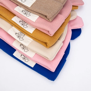 Detailed pile of thick knitted bear hats in various colors with stylish woven labels