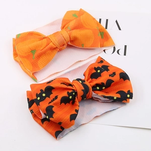 Detail of Halloween baby headbands featuring orange waffle fabric bows with pumpkin and bat prints