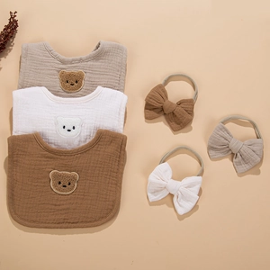 Detail of 4-layer cotton gauze baby bibs and bow headbands with cute bear embroidery