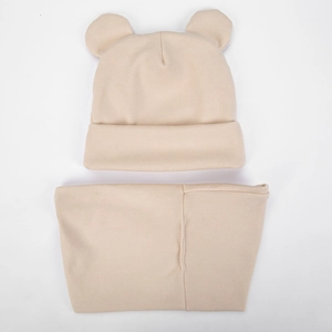 Detailed close-up of beige infant hat and scarf set featuring cute bear ear accents