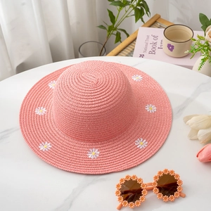 Pink straw sun hat with white daisy embroidery and matching orange floral sunglasses