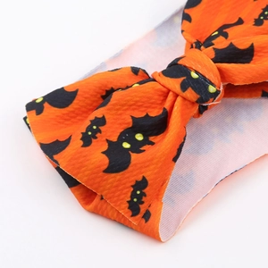 Detail of Halloween bow headband with orange fabric and black bat print texture