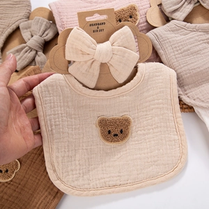 Detail of 4-layer cotton gauze baby bib and bow headband set with teddy bear patch