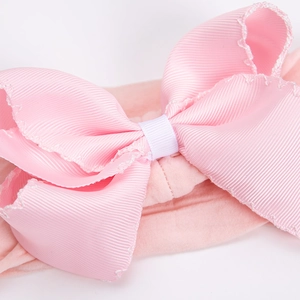 Detail of pink ribbed bow headband with wavy stitching on soft nylon elastic band