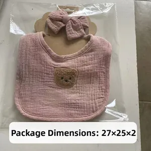 Detail view of 4-layer cotton gauze baby bib with teddy bear patch in package