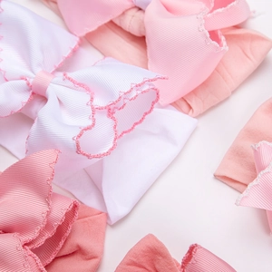 Close-up of baby nylon headbands with scalloped edge polyester bows in soft pastel colors