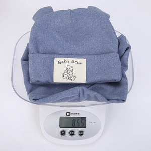 Blue knit baby bear hat with cute ears, weighing 85.5g on a digital scale for infants