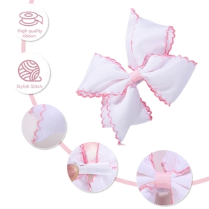 Detail of pink-edged white ribbon bow hair clip with silver alligator clip backing
