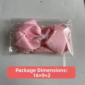 Detail view of pink bow nylon headband showing soft texture and 16x9x2 packaging size