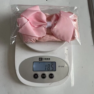 Detail showing a light pink multi-layer grosgrain ribbon bow headband weighing 18.5g