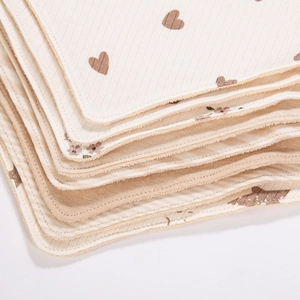 Gros plan de bavoirs en coton pour bébé avec motifs cœurs et bordures soignées