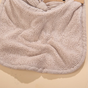 Detailed macro view of khaki cotton baby bib showing soft absorbent terry cloth texture