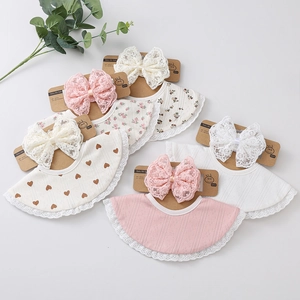 Détail de cinq bavoirs bébé en coton avec bordure en dentelle et grands nœuds