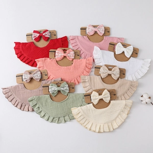 Detail of 8 colors ruffled cotton bibs and lace bow headbands on kraft paper display