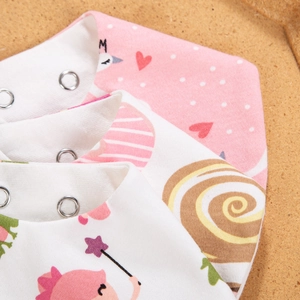 Close-up of baby cotton bibs featuring adjustable metal snaps and cartoon prints