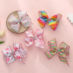 Détail de cinq barrettes à nœuds avec motifs arc-en-ciel, fleurs et centre en cristal poli