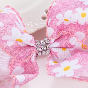 Détail macro du nœud papillon marguerite rose avec centre incrusté de strass argentés