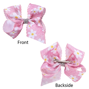Vues avant et arrière de pinces à cheveux rose à marguerites avec strass et métal