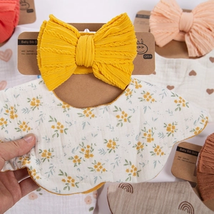 Detail of baby bib and headband set with yellow floral pattern and ruffled edges