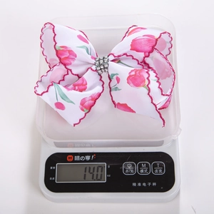 Vue détaillée d'une barrette à nœud avec strass sur une balance pesant 14,0 g