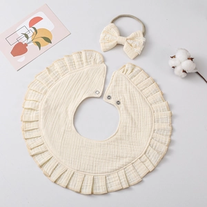Newborn cream muslin cotton bib with ruffle lace and matching bow headband set