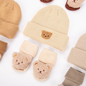 Detailed view of baby ribbed knit hat and cozy bear decor socks in warm beige tones
