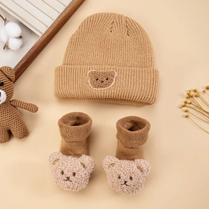 Close-up of khaki infant knit hat and socks set with 3D plush bear decorative accents