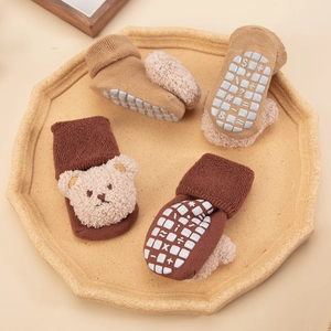 Detailed view of baby grip socks with plush bear decor and non-slip silicone pads