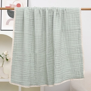 Detail der mintgrünen 6-lagigen Musselin-Babydecke mit zarter weißer Spitzenbordüre