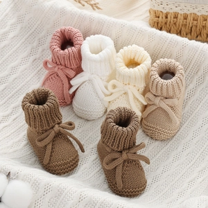 Schattige gebreide babyloopschoentjes met strikjes in verschillende zachte pastelkleuren