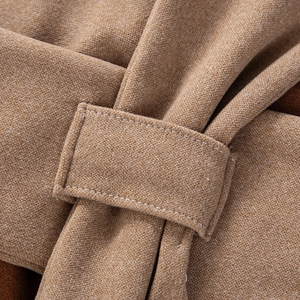 Macro shot of soft knit texture and woven loop detail on camel winter baby scarf