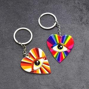 Detailed close-up of rainbow evil eye heart-shaped acrylic keychains on stone texture