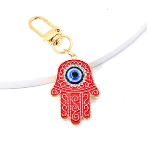 Close-up of red Hamsa Hand keychain with blue Evil Eye and sparkling crystals inlay