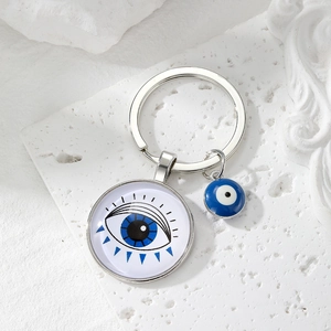 Macro view of blue Evil Eye glass charm keychain with silver metal pendant details