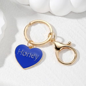 Detail of blue enamel heart keychain with Honey text and gold-tone lobster clasp
