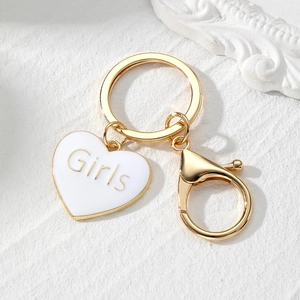 Detailed close-up of a golden heart keychain with Girls lettering and lobster clasp
