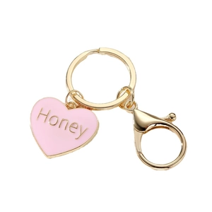 Golden keychain with pink enamel heart pendant and Honey text on white background