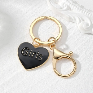 Close-up of golden lobster clasp and black heart pendant with 'Girls' lettering