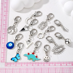 Mini alloy charms set with lobster clasps featuring dinosaur, smile and cosmic motifs